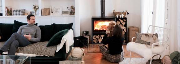 couple avec chien devant poêle à bois