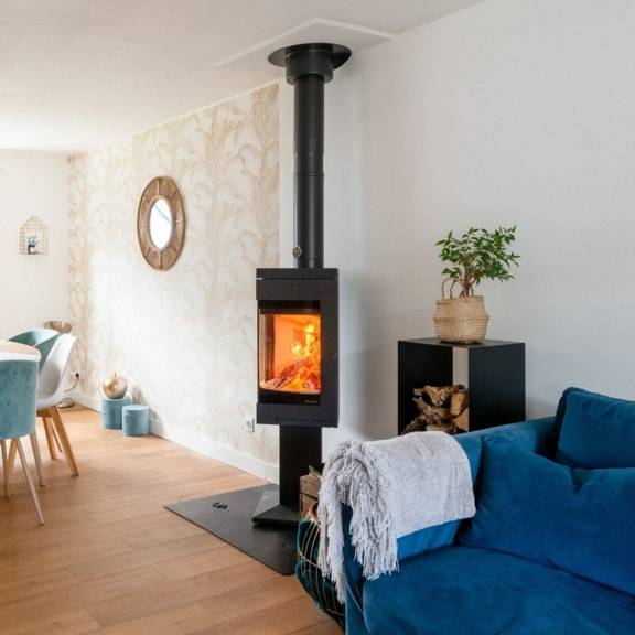 poêle à bois Nordpeis Quadro en feu dans la pièce à vivre d'une maison moderne