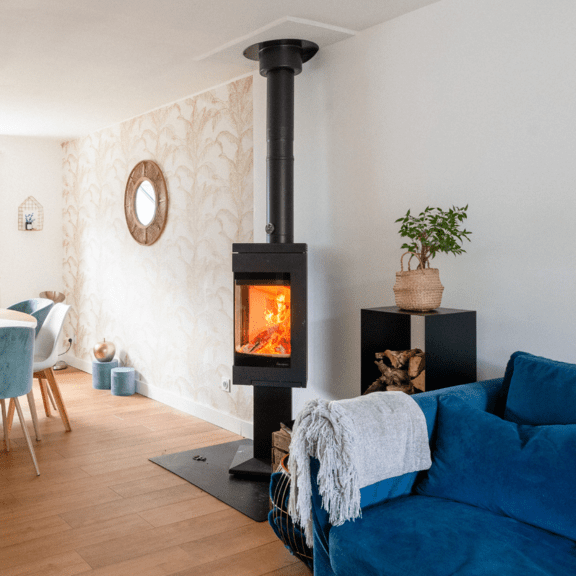poêle à bois Nordpeis Quadro en feu dans la pièce à vivre d'une maison moderne