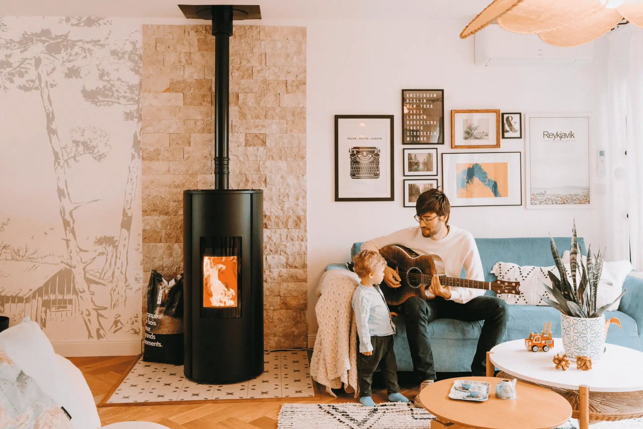 père guitare et fils près d'un poêle à granulés