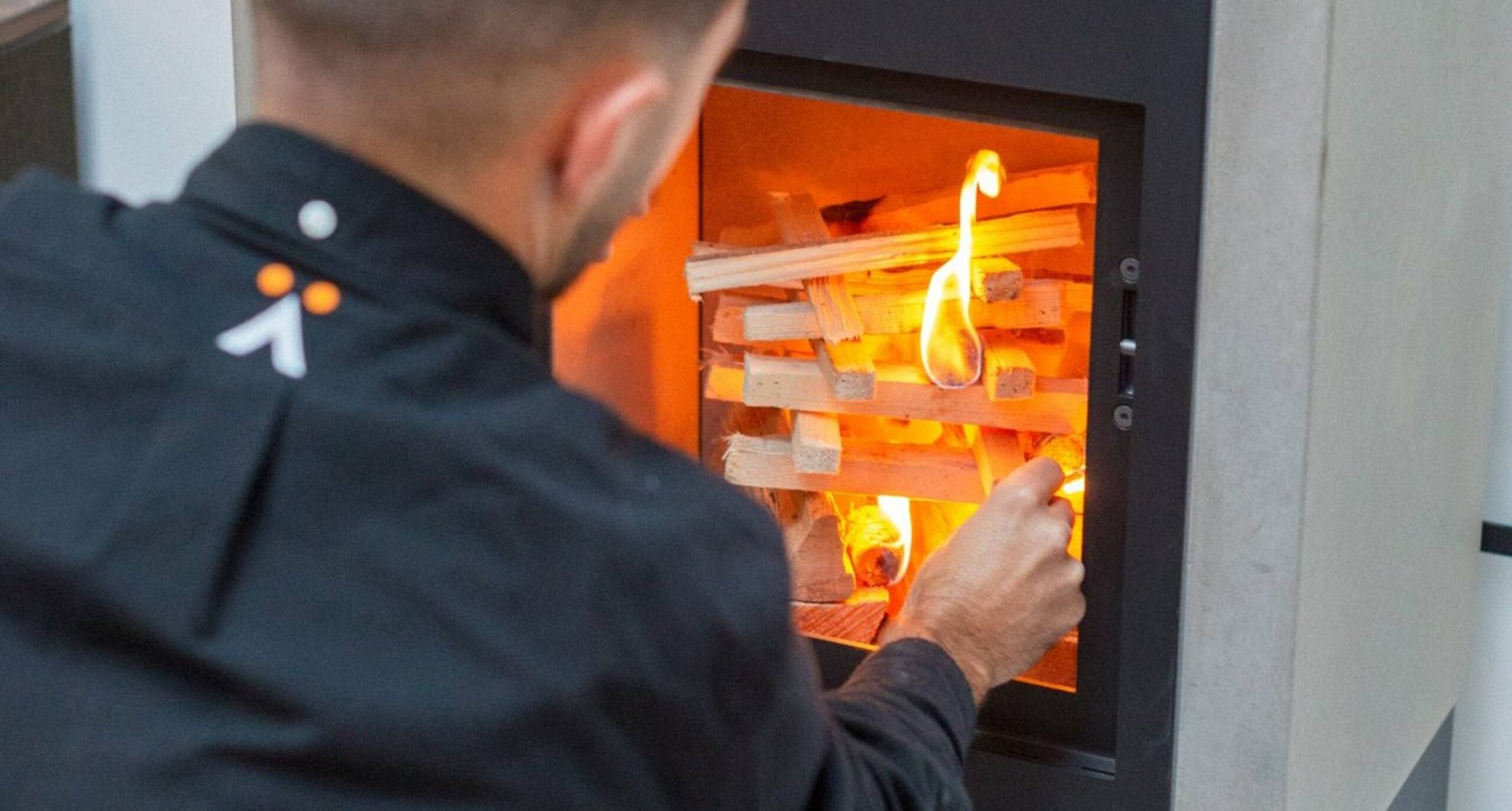 homme allumant un poêle à bois